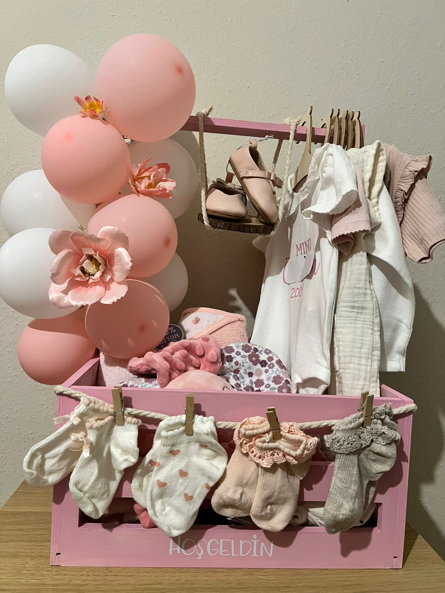 Baby-Geschenkarrangement in Rosa und Weiß mit Ballondeko und Textilien